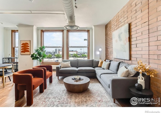 2245 Blake St Unit D, Denver, CO 80205 - living room featuring brick wall, plenty of natural light, and wood finished floors
