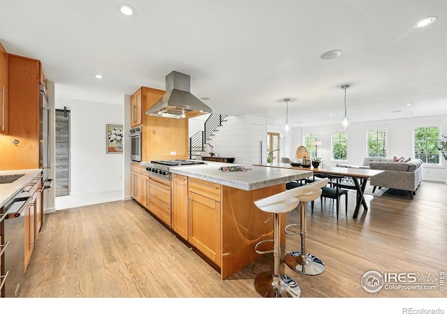 2970 21st St, Boulder, CO 80304 - kitchen featuring island exhaust hood, stainless steel appliances, open floor plan, a breakfast bar, and light wood-style floors
