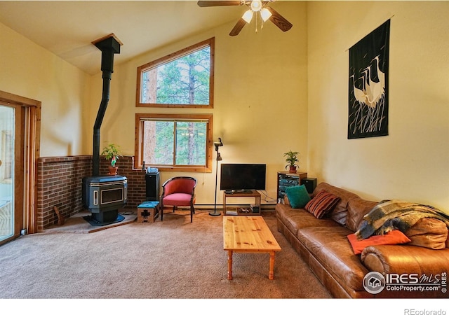 38 Navajo Trl, Nederland, CO 80466 - carpeted living room with a wood stove, a high ceiling, and a ceiling fan