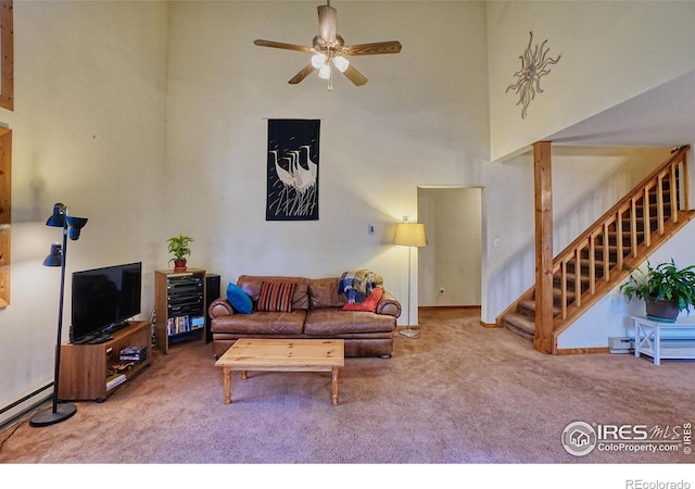 38 Navajo Trl, Nederland, CO 80466 - living area with carpet floors, a high ceiling, stairs, a baseboard radiator, and ceiling fan