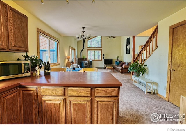 38 Navajo Trl, Nederland, CO 80466 - kitchen featuring stainless steel microwave, carpet, dark countertops, a chandelier, and open floor plan