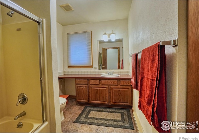 38 Navajo Trl, Nederland, CO 80466 - bathroom with toilet, vanity, combined bath / shower with glass door, and a textured wall