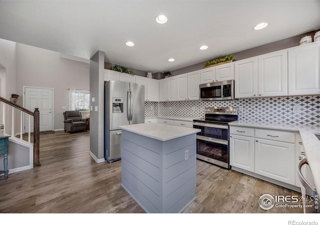 5822 Shenandoah Ave, Firestone, CO 80504 - kitchen with appliances with stainless steel finishes, light countertops, a center island, white cabinetry, and recessed lighting