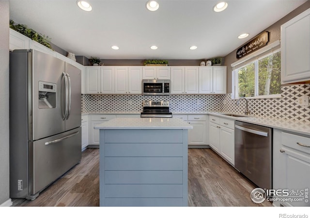 5822 Shenandoah Ave, Firestone, CO 80504 - kitchen featuring appliances with stainless steel finishes, a sink, light countertops, white cabinets, and a center island
