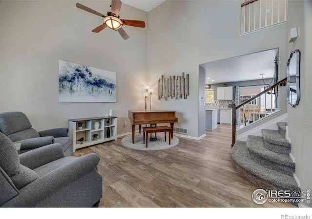 5822 Shenandoah Ave, Firestone, CO 80504 - living area with a ceiling fan, light wood finished floors, a high ceiling, stairway, and baseboards