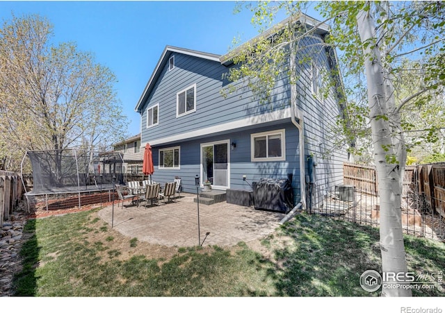 5822 Shenandoah Ave, Firestone, CO 80504 - rear view of property with a trampoline and a patio area