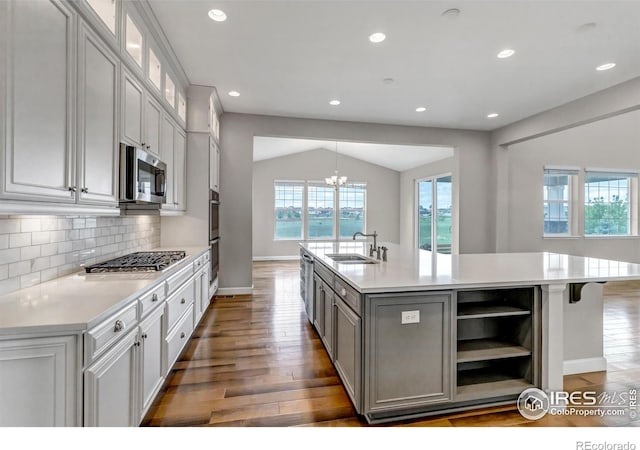 913 Green Mountain Dr, Erie, CO 80516 - kitchen with a sink, stainless steel appliances, a center island with sink, tasteful backsplash, and light countertops