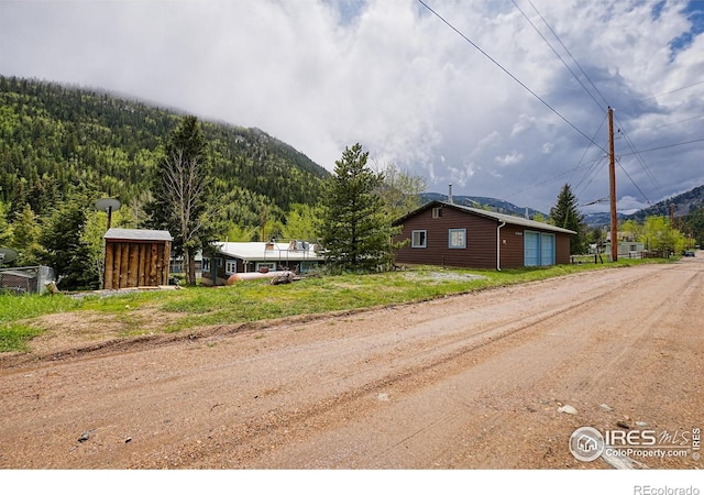 545 Eldorado Ave, Nederland, CO 80466 - view of side of property featuring a mountain view, dirt driveway, and a view of trees