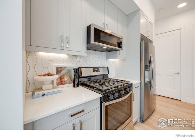 2876 W 53rd Ave Unit 301, Denver, CO 80221 - kitchen with stainless steel appliances, backsplash, light wood-style floors, light countertops, and recessed lighting