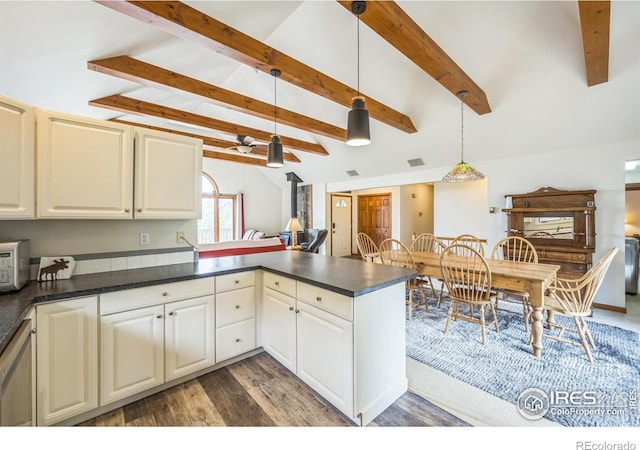 17284 W County Road 74e, Red Feather Lakes, CO 80545 - kitchen featuring dark countertops, a peninsula, wood finished floors, hanging light fixtures, and white microwave