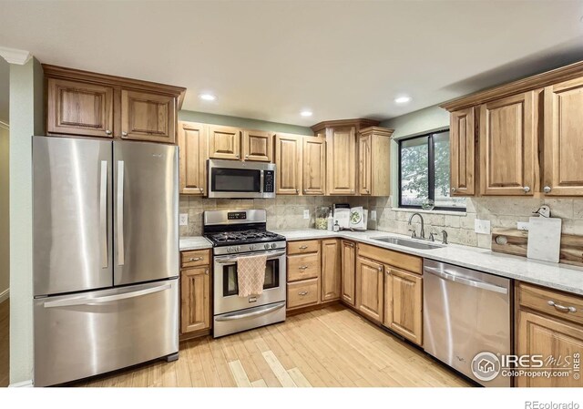 1510 22nd Ave, Longmont, CO 80501 - kitchen with appliances with stainless steel finishes, a sink, light wood-type flooring, backsplash, and recessed lighting