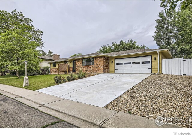 1510 22nd Ave, Longmont, CO 80501 - view of front of home with concrete driveway, a garage, brick siding, and a chimney