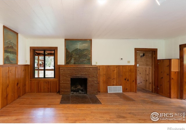35106 Boulder Canyon Dr, Boulder, CO 80302 - unfurnished living room with a wainscoted wall, wooden walls, wood finished floors, and a fireplace