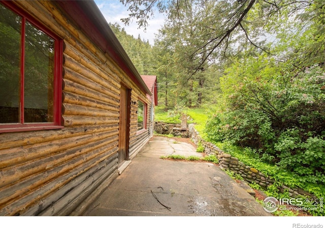 35106 Boulder Canyon Dr, Boulder, CO 80302 - view of home's exterior featuring log exterior, a patio, and a wooded view