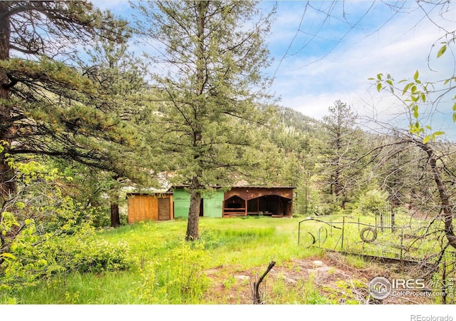 35106 Boulder Canyon Dr, Boulder, CO 80302 - view of yard with an outbuilding and a view of trees
