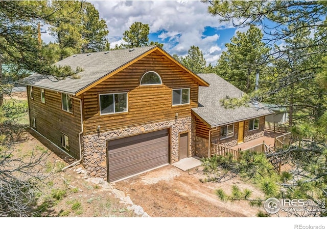 24192 W County Road 74e, Red Feather Lakes, CO 80545 - chalet / cabin featuring stone siding, an attached garage, roof with shingles, and dirt driveway