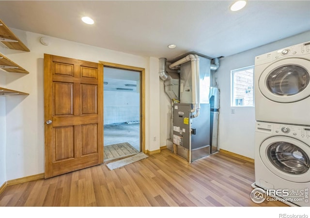 24192 W County Road 74e, Red Feather Lakes, CO 80545 - washroom with stacked washer / dryer, heating unit, light wood finished floors, baseboards, and recessed lighting
