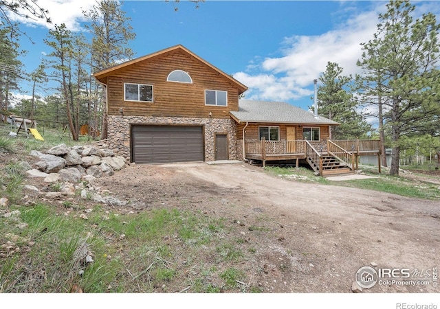 24192 W County Road 74e, Red Feather Lakes, CO 80545 - rustic home featuring stone siding, an attached garage, driveway, and a deck