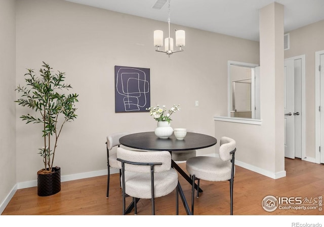 13598 Via Varra Unit 404, Broomfield, CO 80020 - dining space featuring wood finished floors, baseboards, and a chandelier