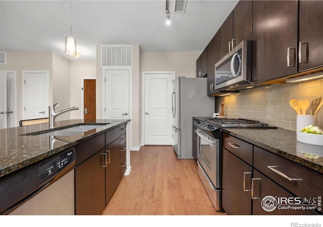13598 Via Varra Unit 404, Broomfield, CO 80020 - kitchen with stainless steel appliances, light wood-type flooring, a sink, dark brown cabinetry, and tasteful backsplash