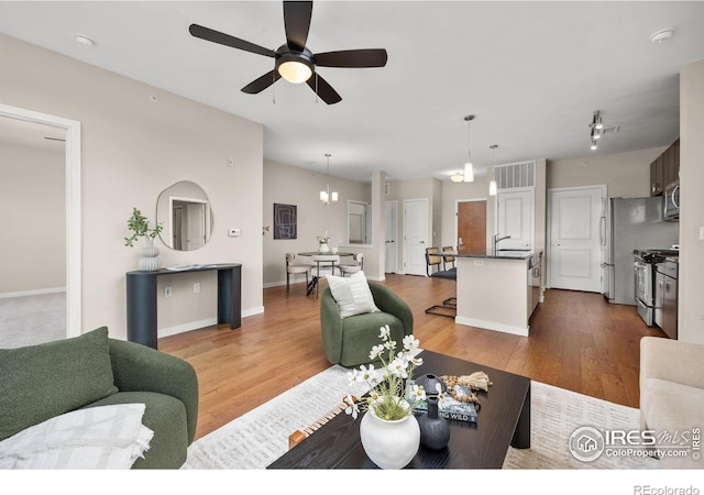 13598 Via Varra Unit 404, Broomfield, CO 80020 - living room with a ceiling fan, wood finished floors, and baseboards