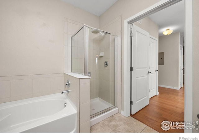 13598 Via Varra Unit 404, Broomfield, CO 80020 - full bathroom with a garden tub, a shower stall, electric panel, and tile patterned floors