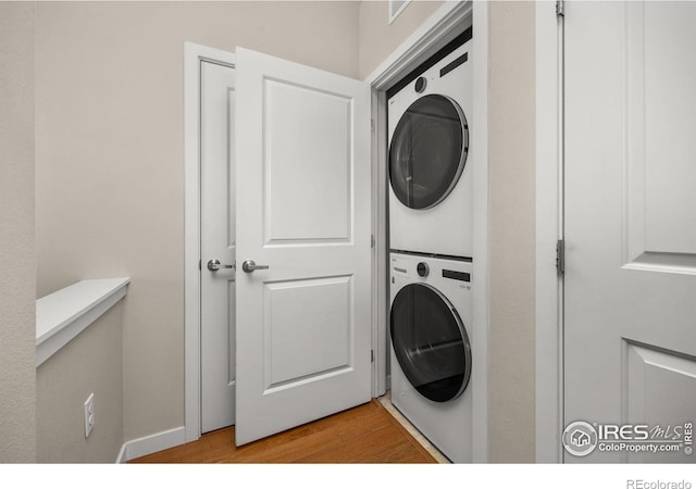 13598 Via Varra Unit 404, Broomfield, CO 80020 - washroom featuring stacked washer / drying machine and light wood finished floors