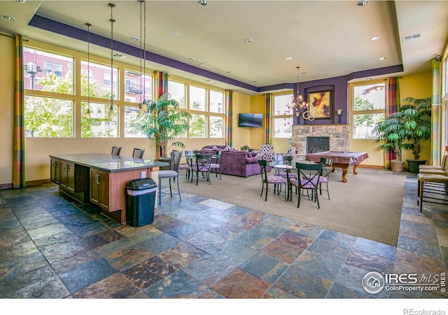13598 Via Varra Unit 404, Broomfield, CO 80020 - dining area with a raised ceiling, a fireplace, stone tile flooring, baseboards, and recessed lighting