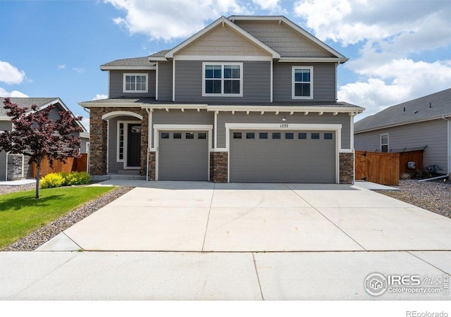 1257 Wild Basin Rd, Severance, CO 80550 - craftsman-style house featuring an attached garage, concrete driveway, and stone siding