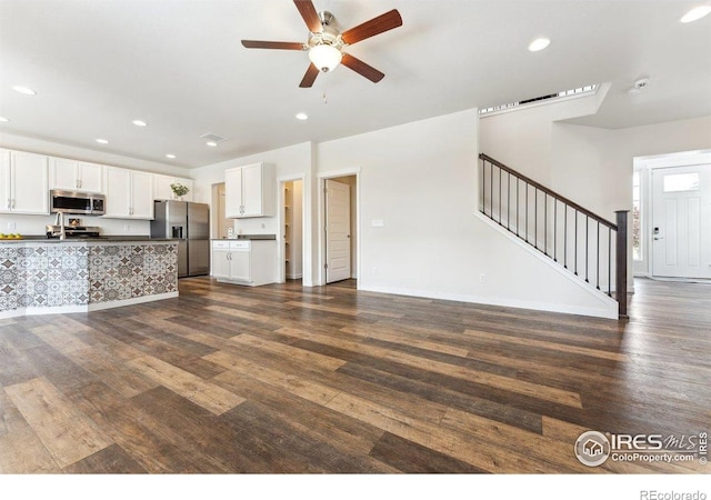 1257 Wild Basin Rd, Severance, CO 80550 - unfurnished living room featuring dark wood-style flooring, stairs, a ceiling fan, recessed lighting, and baseboards