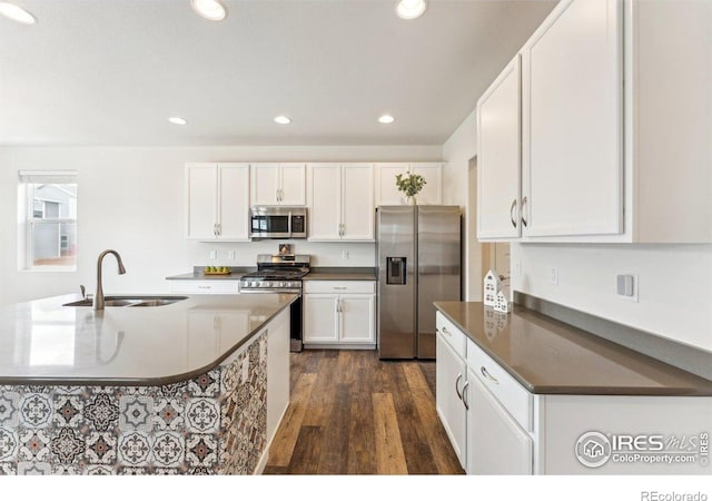 1257 Wild Basin Rd, Severance, CO 80550 - kitchen with stainless steel appliances, a sink, dark wood-style flooring, dark countertops, and white cabinets
