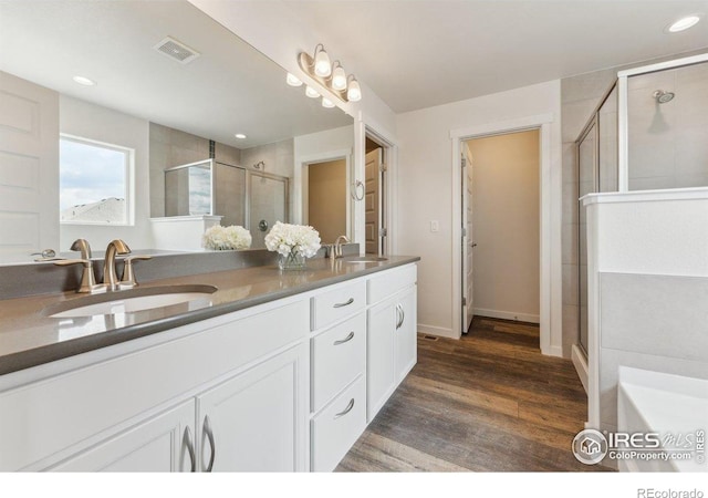1257 Wild Basin Rd, Severance, CO 80550 - full bathroom with double vanity, wood finished floors, a stall shower, recessed lighting, and baseboards