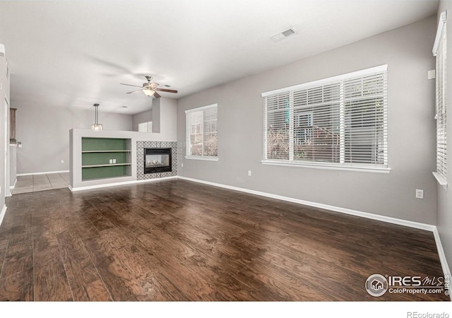 13024 Grant Cir W Unit A, Thornton, CO 80241 - unfurnished living room with a ceiling fan, baseboards, wood finished floors, and a tiled fireplace