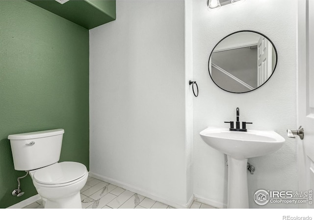 13024 Grant Cir W Unit A, Thornton, CO 80241 - bathroom featuring marble finish floors, toilet, and baseboards
