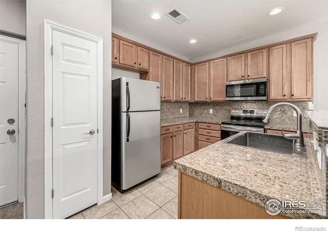 13024 Grant Cir W Unit A, Thornton, CO 80241 - kitchen with appliances with stainless steel finishes, a sink, tasteful backsplash, light tile patterned floors, and light countertops