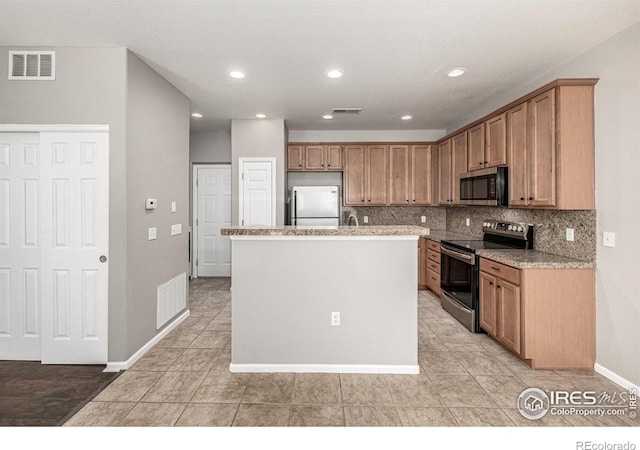 13024 Grant Cir W Unit A, Thornton, CO 80241 - kitchen with appliances with stainless steel finishes, tasteful backsplash, a kitchen island, baseboards, and recessed lighting