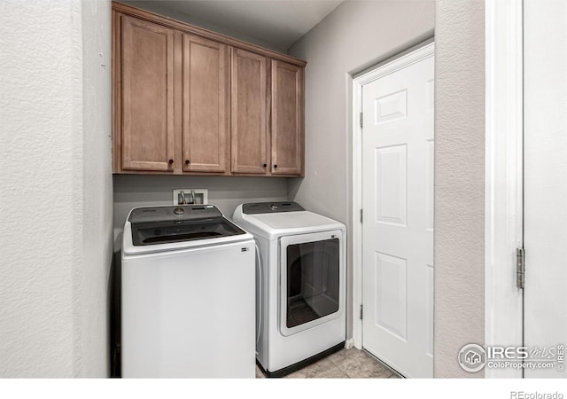 13024 Grant Cir W Unit A, Thornton, CO 80241 - laundry area featuring cabinet space, washing machine and clothes dryer, and light tile patterned flooring