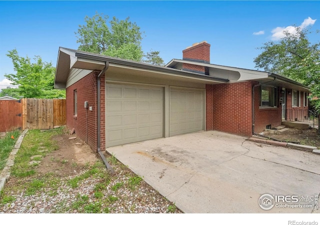 1200 Emigh St, Fort Collins, CO 80524 - view of property exterior with brick siding, an attached garage, concrete driveway, and a chimney