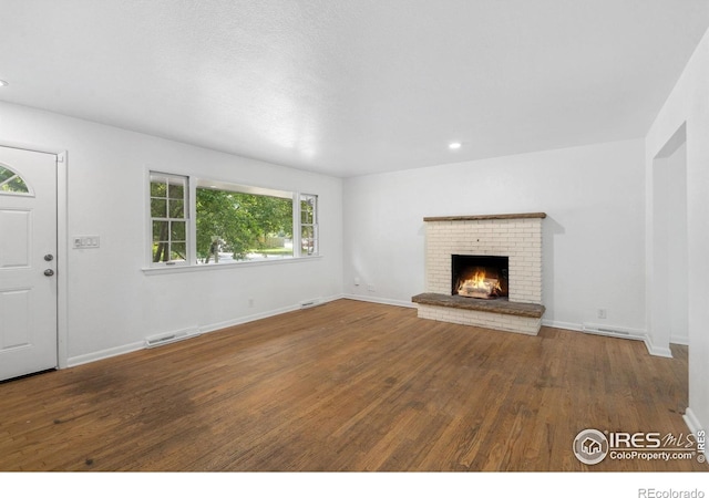 1200 Emigh St, Fort Collins, CO 80524 - unfurnished living room with wood finished floors, a brick fireplace, baseboards, and recessed lighting