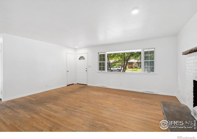 1200 Emigh St, Fort Collins, CO 80524 - unfurnished living room featuring a brick fireplace, light wood-style flooring, baseboards, and recessed lighting