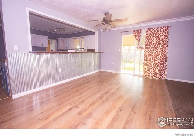815 Park St, Fort Morgan, CO 80701 - unfurnished living room featuring a ceiling fan, wood finished floors, ornamental molding, baseboards, and a chandelier