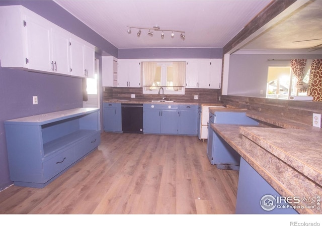 815 Park St, Fort Morgan, CO 80701 - kitchen featuring dishwasher, white cabinets, light wood finished floors, backsplash, and a sink