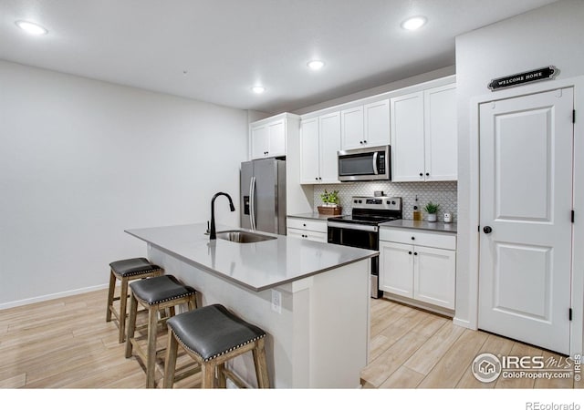 2086 Autumn Moon Dr Unit 7, Windsor, CO 80550 - kitchen featuring stainless steel appliances, a sink, a kitchen bar, light wood finished floors, and recessed lighting