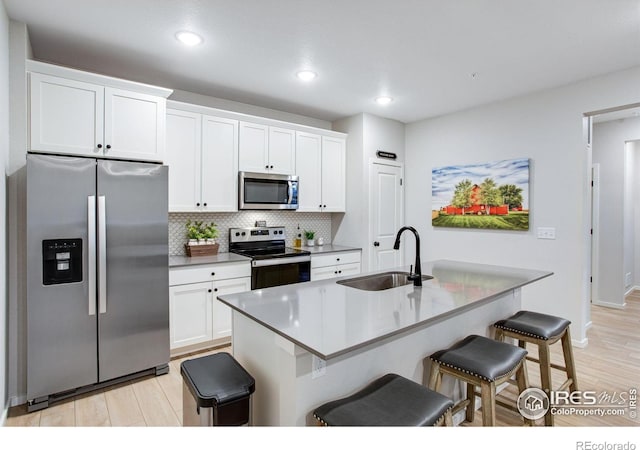 2086 Autumn Moon Dr Unit 7, Windsor, CO 80550 - kitchen with stainless steel appliances, a sink, a kitchen bar, white cabinets, and decorative backsplash
