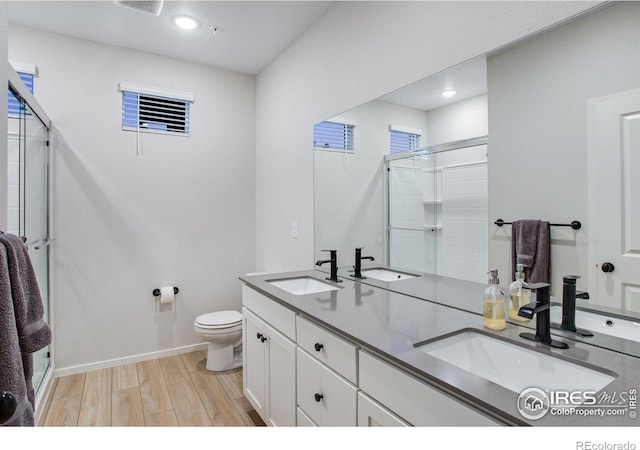 2086 Autumn Moon Dr Unit 7, Windsor, CO 80550 - full bathroom featuring a stall shower, wood finished floors, toilet, double vanity, and baseboards