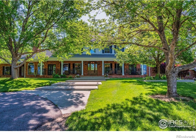 20360 County Road 3, Berthoud, CO 80513 - view of front of property with covered porch, a front lawn, and brick siding