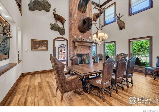 20360 County Road 3, Berthoud, CO 80513 - dining room with a towering ceiling, light wood-type flooring, a chandelier, baseboards, and arched walkways
