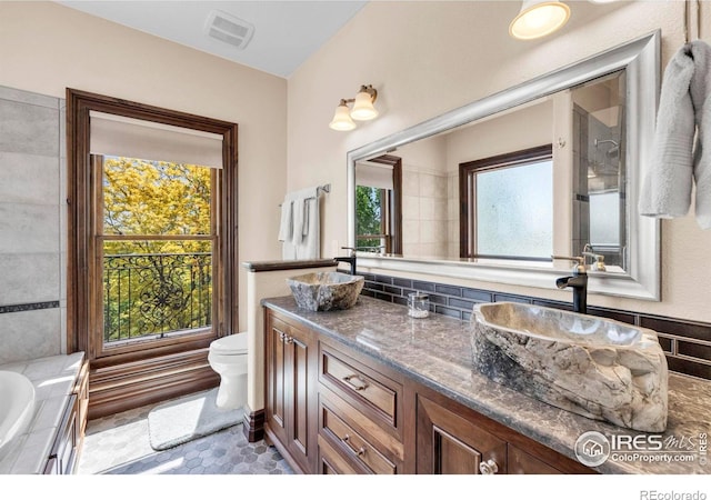20360 County Road 3, Berthoud, CO 80513 - bathroom featuring vanity, toilet, a tub to relax in, and decorative backsplash