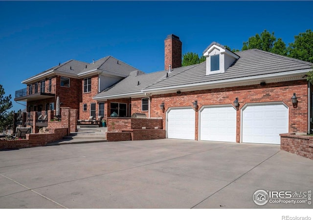 20360 County Road 3, Berthoud, CO 80513 - view of front of property featuring concrete driveway, brick siding, a chimney, an attached garage, and a tile roof