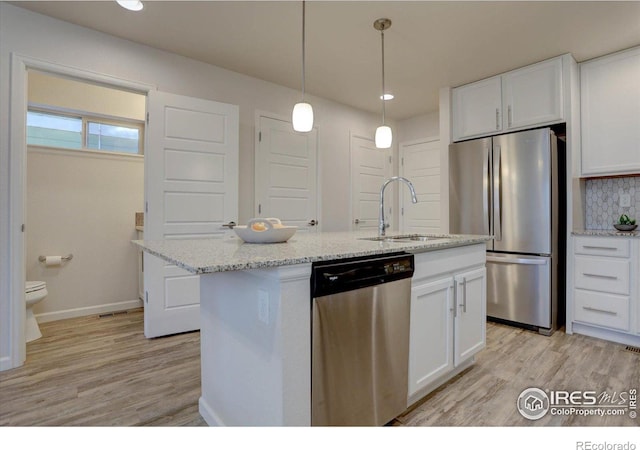 5863 Boston St, Denver, CO 80238 - kitchen featuring appliances with stainless steel finishes, a sink, white cabinets, light wood-style floors, and decorative backsplash